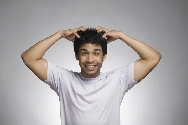 Homem fazendo um rosto com as mãos no cabelo — Fotografia de Stock