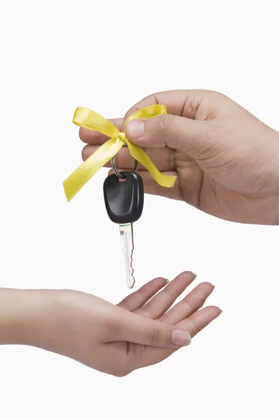 Hand giving a car key to another person — Stock Photo, Image