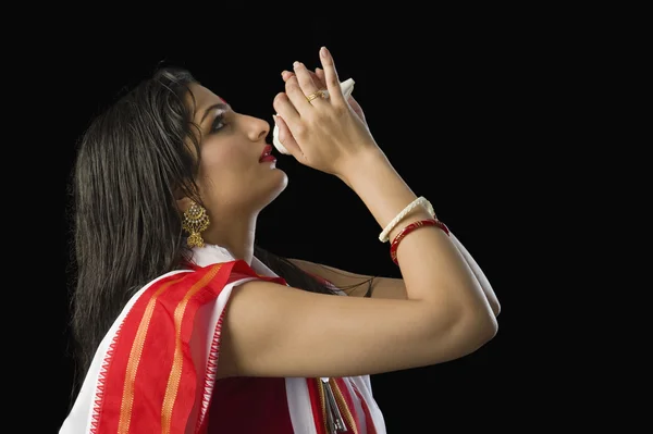 Woman in a Bengali sari blowing conch shell — Stock Photo, Image