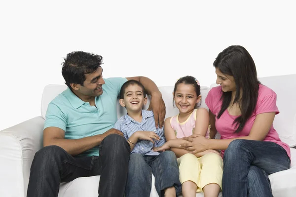 Famiglia seduta su un divano — Foto Stock