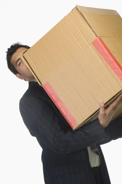 Empresário segurando uma caixa de papelão — Fotografia de Stock