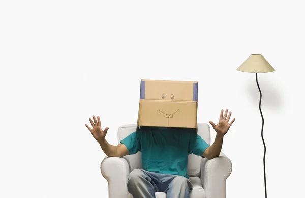 Чоловік закриває обличчя в картонній коробці — стокове фото