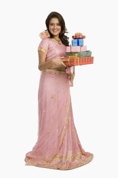 Mujer en vestido tradicional sosteniendo regalos — Foto de Stock