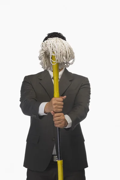 Businessman holding a broom — Stock Photo, Image