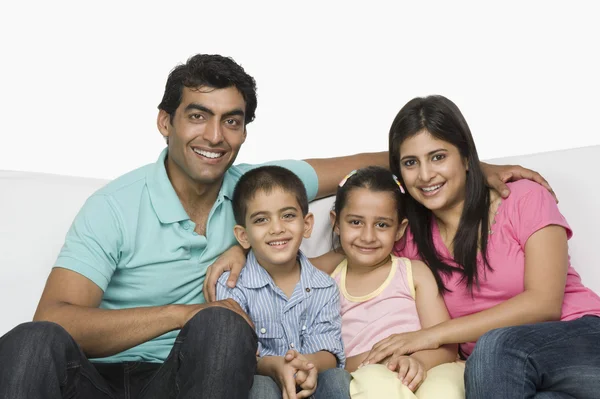 Família feliz sentada em um sofá — Fotografia de Stock