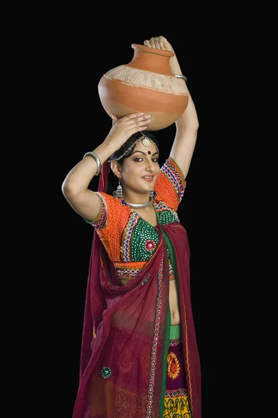Femme en choli lehenga portant pot d'eau — Photo