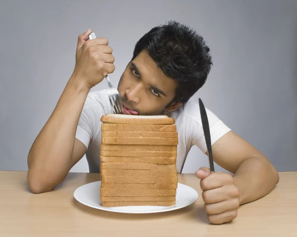 Mann leckt Lippen vor Brotscheiben — Stockfoto