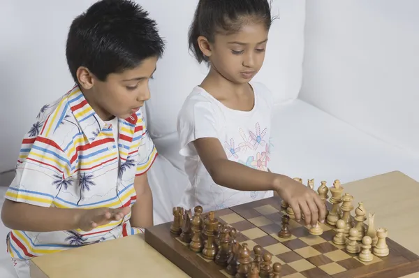 Garçon et une fille jouant aux échecs — Photo