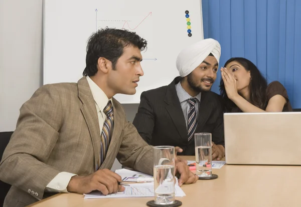 Businesswoman whispering in a board room — Stock Photo, Image