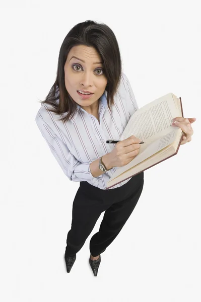 Femme d'affaires marquant sur un livre — Photo