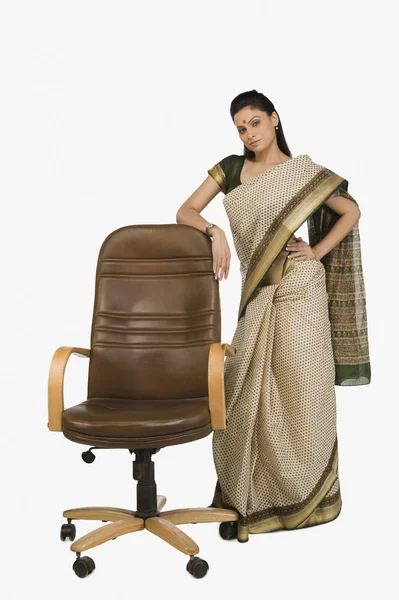 Zakenvrouw permanent naast een stoel van het Bureau — Stockfoto
