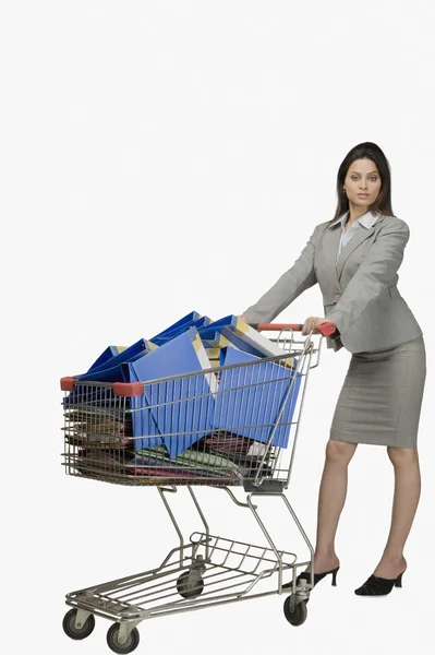 Empresária empurrando um carrinho de compras cheio de arquivos — Fotografia de Stock