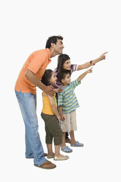 Föräldrar med sina barn och pekar Stockbild