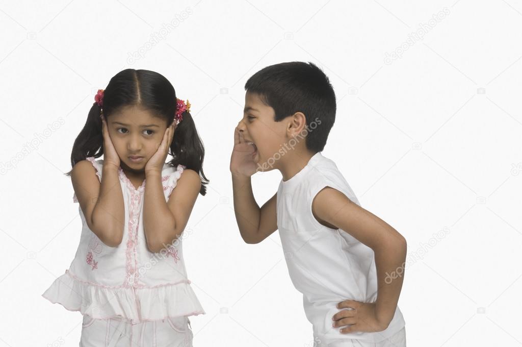 Girl covering her ears while her brother shouting