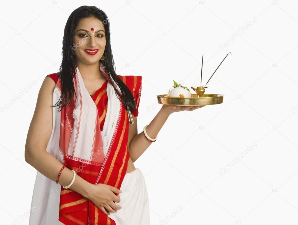 Woman in a Bengali sari holding pooja thali