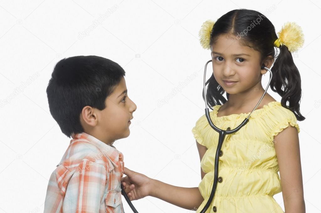 Girl examining a boy with a stethoscope