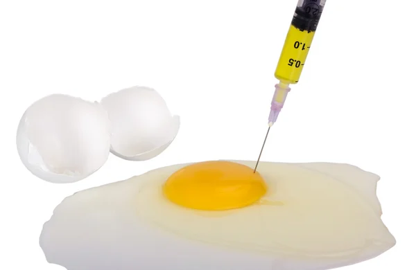 Siringa che inietta liquido giallo nel tuorlo d'uovo — Foto Stock