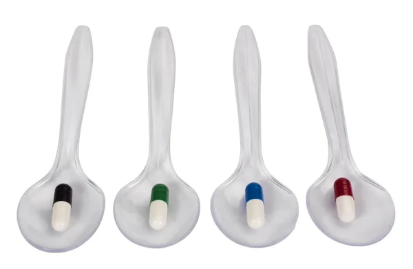 Spoons with capsules — Stock Photo, Image