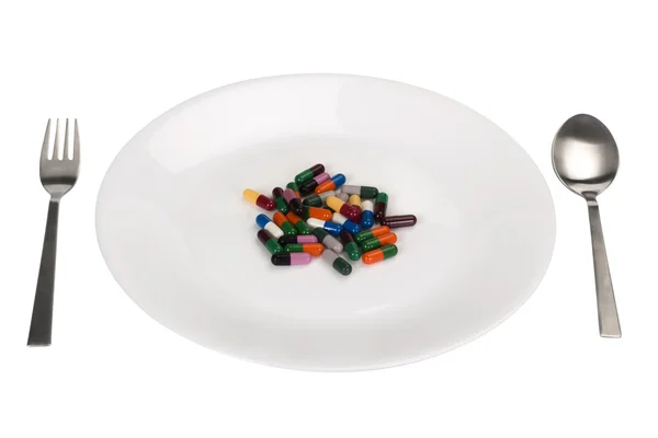 Разнообразные капсулы в тарелке — стоковое фото