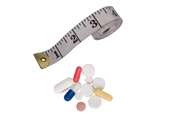 Pilules avec un ruban à mesurer — Photo