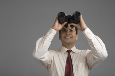 Dürbünle bakan bir iş adamı