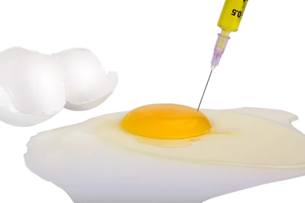 Siringa che inietta liquido giallo nel tuorlo d'uovo — Foto Stock