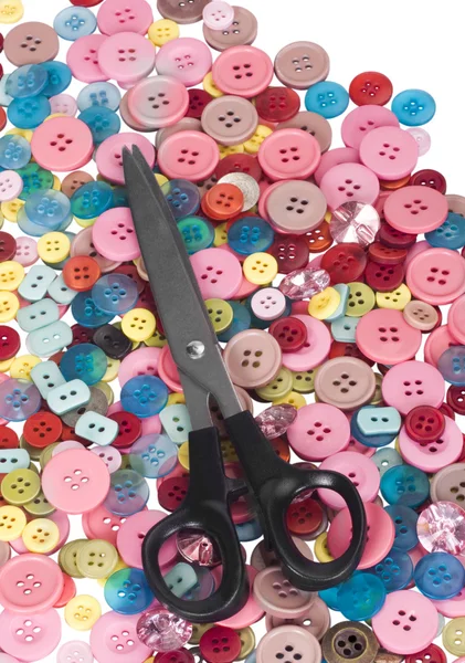 Scissors on a heap of buttons — Stock Photo, Image