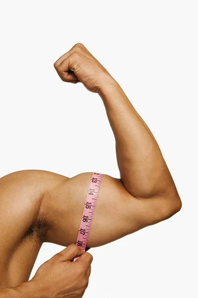 Człowiek pomiaru jego biceps — Zdjęcie stockowe