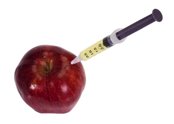 Syringe being injected into an apple — Stock Photo, Image