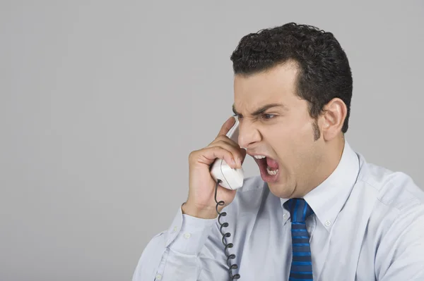 Zakenman schreeuwen op een telefoon beluisteren — Stockfoto