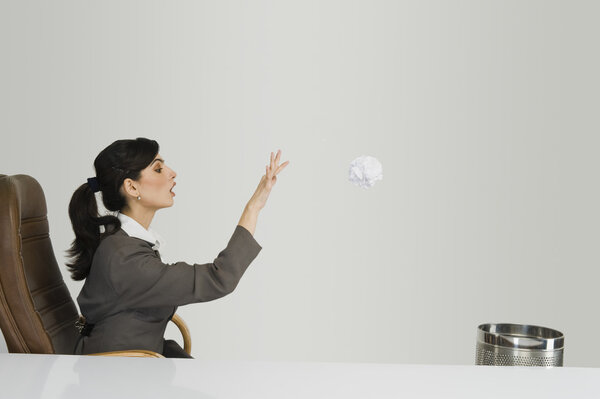Businesswoman throwing crumpled paper