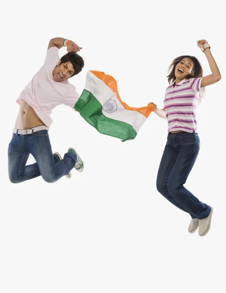 Couple holding Indian flag and jumping — Stock Photo, Image