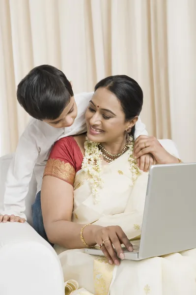 Mulher usando um laptop com seu filho — Fotografia de Stock