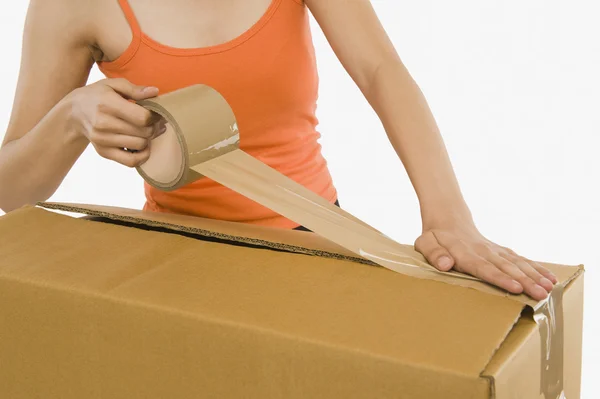 Woman packing cardboard by packing tape — Stock Photo, Image