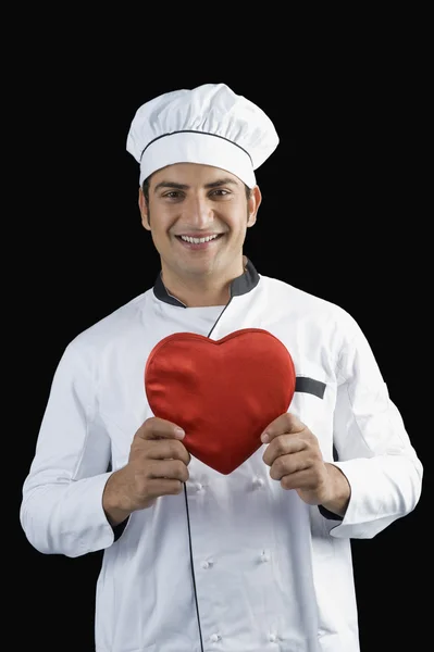 Ritratto di uno chef che regge un regalo a forma di cuore — Foto Stock