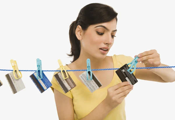 Woman hanging credit cards on a clothesline — Stock Photo, Image