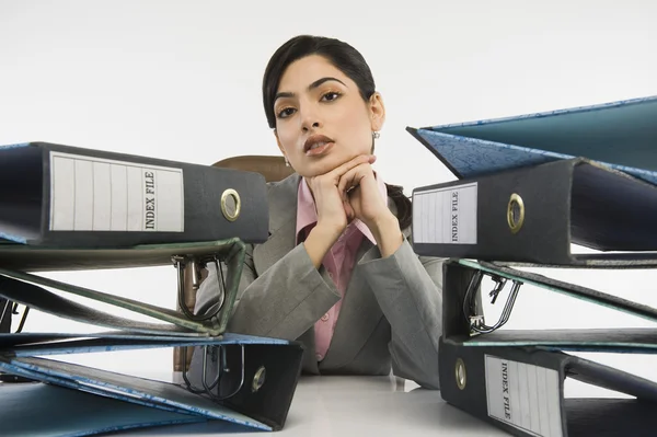 Stack of ring binders in front of a businesswoman — Stock Photo, Image