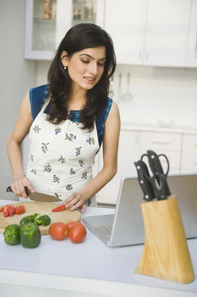Mujer cocinando con la receta en un ordenador portátil —  Fotos de Stock