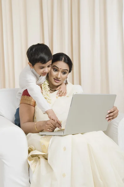 女人与她的儿子使用一台笔记本电脑 — 图库照片