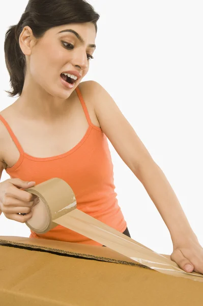 Woman packing cardboard by packing tape — Stock Photo, Image