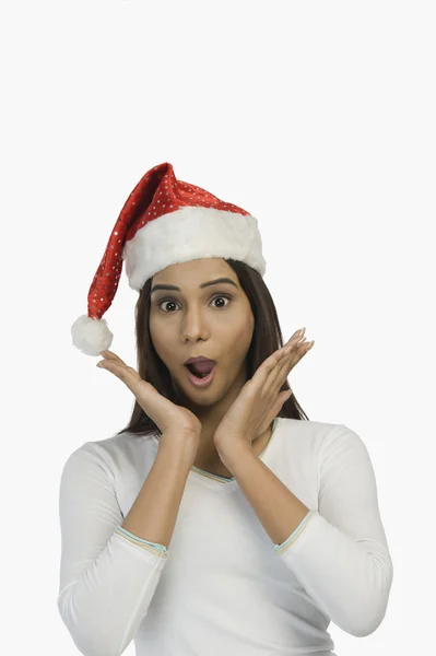 Woman wearing a Santa hat and looking surprised — Stock Photo, Image