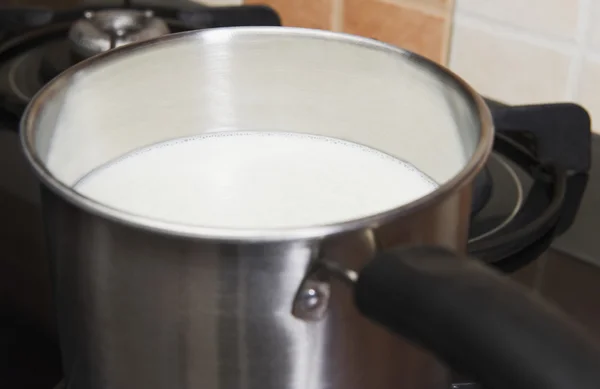 Mleko w garnku na gazie palnik kuchenka — Zdjęcie stockowe