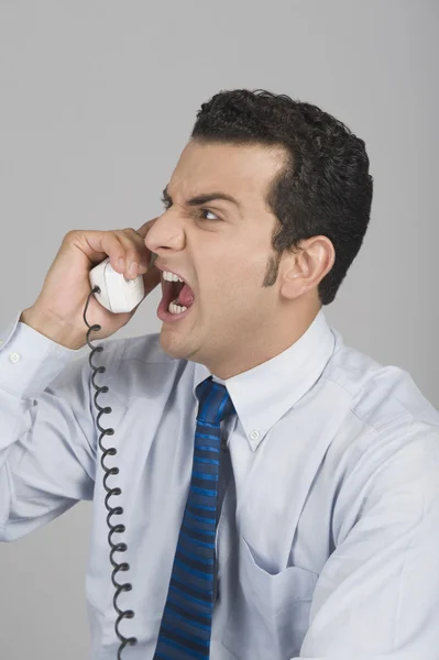 Businessman shouting over a telephone — Stock Photo, Image