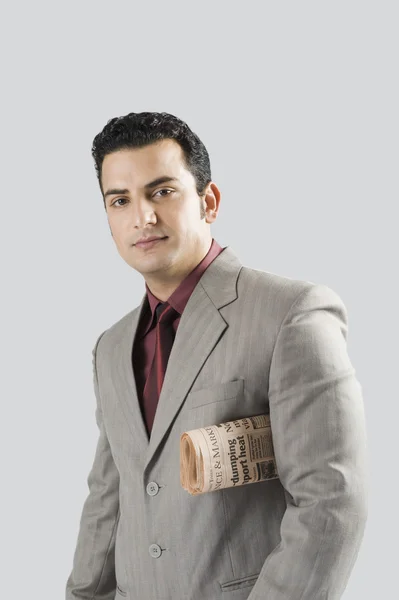Businessman with a newspaper under his arm — Stock Photo, Image