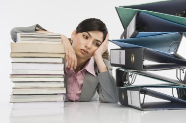 Stack of books in front of a businesswoman clipart