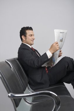 Elinde gazete tutan bir iş adamı