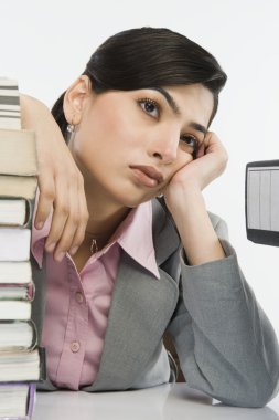 Stack of books in front of a businesswoman clipart