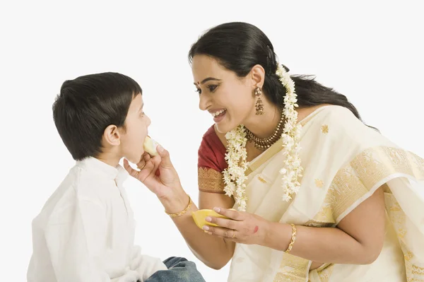 Woman feeding her son — Stock Photo, Image