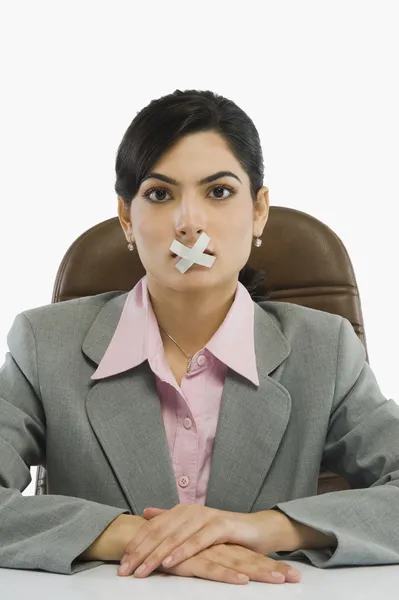 Businesswoman with adhesive tape over her mouth — Stock Photo, Image