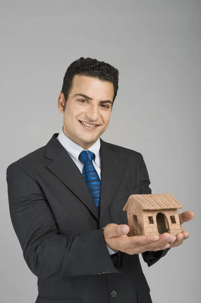 Empresario sosteniendo una casa modelo —  Fotos de Stock